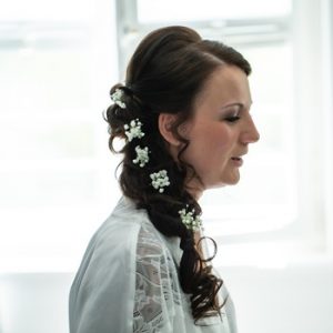 Braut in Hochzeitskleid mit Blumen im Haar