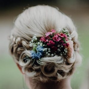 Braut mit Flechtfrisur und Blumen im Haar